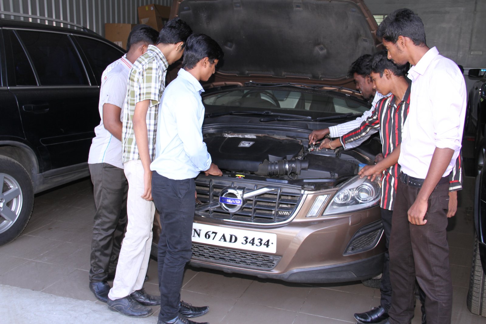 Worker polishing a black car in workshop